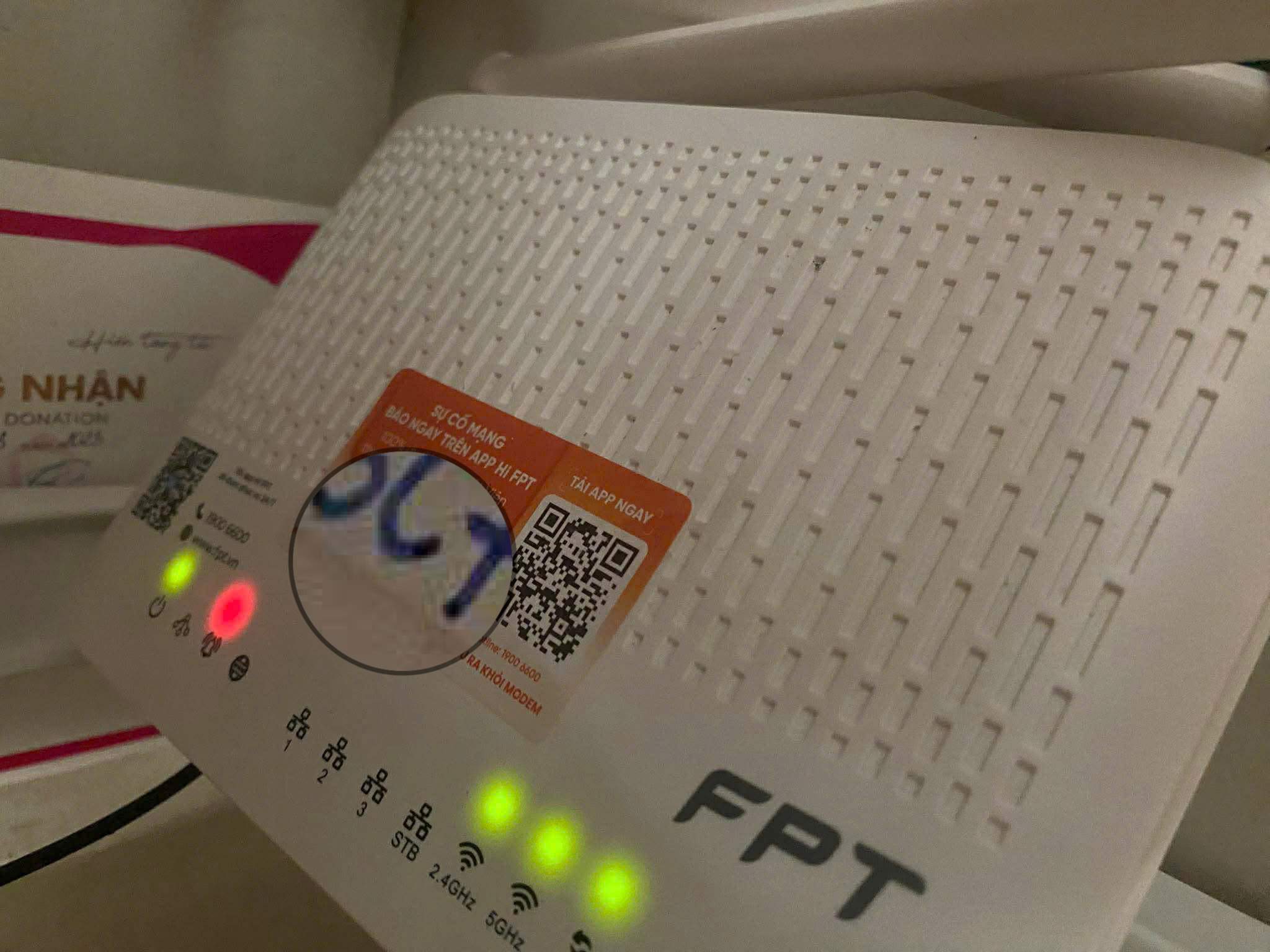 Nhãn Hi FPT màu cam dán trên modem FPT — số hợp đồng được kỹ thuật viên ghi lên nhãn khi lắp đặt